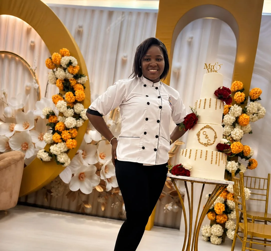 Baker from Chinny Cakes & More standing beside a wedding cake